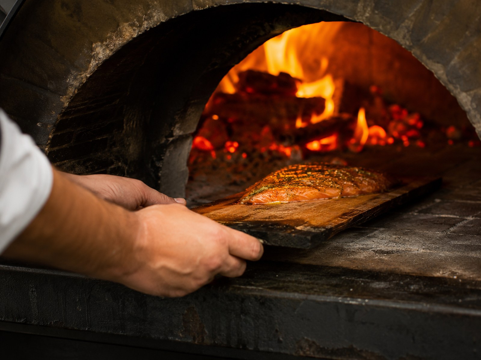 The wood-fired oven glowing at Cedar & Ember